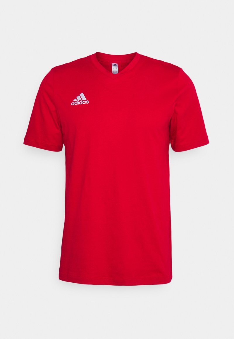 Punane puuvillane t-särk lühikeste varrukatega, V-kaelusega ja valge Adidas logo vasakul rinnal. Sile tekstuur, nähtavaid mustreid pole.
