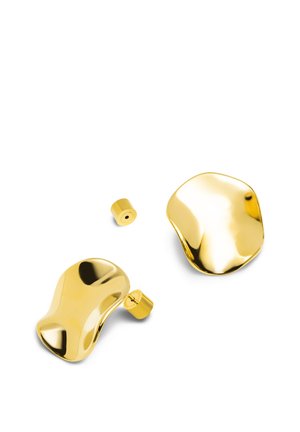 Paire de boucles d'oreilles clous en métal doré brillant de forme irrégulière avec de petits dos cylindriques sur fond blanc.