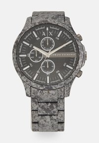 Montre en acier inoxydable noir texturé avec fonction chronographe, bracelet gris moucheté, accents argentés et marqueurs d'heure blancs contrastants.