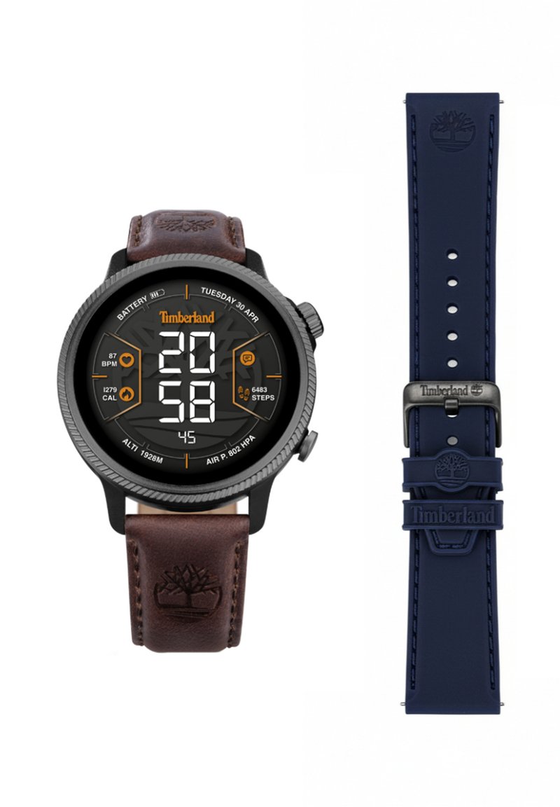 Digital watch with a black case, brown leather strap, and navy silicone strap. Features a round display with large digital numbers and icons.