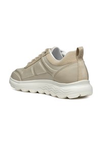 Beige Sneaker mit einem Obermaterial aus Mesh und Wildleder, strukturierten Akzenten und einer dicken weißen Gummisohle mit gewellten Mustern.