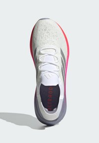 Scarpa atletica leggera in mesh bianco e grigio, con suola in gomma rosa e viola. Presenta un design con lacci e dettagli testurizzati.