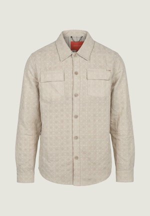 Giacca beige chiaro con bottoni, motivo trapuntato a diamante, due tasche con patta sul petto e colletto appuntito.