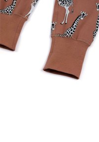 Brune bomulds sweatshirtærmer med sort og hvid giraffemønster. Manchetterne er afsluttet med en strikket tekstur.