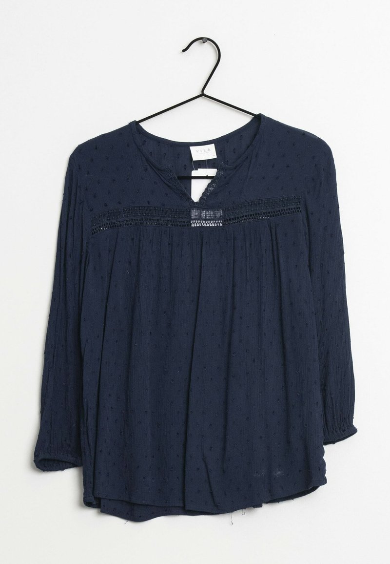 Granatowa bluzka z długim rękawem, wykonana z teksturowanej tkaniny, z plisami z przodu i koronkowymi zdobieniami wzdłuż dekoltu. Zaprojektowana z luźnym krojem.