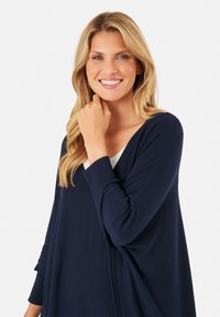 Cardigan a maglia blu navy con vestibilità morbida, scollatura a V e polsini a coste. Tessuto morbido, leggero, progettato per comfort e facilità d'uso.