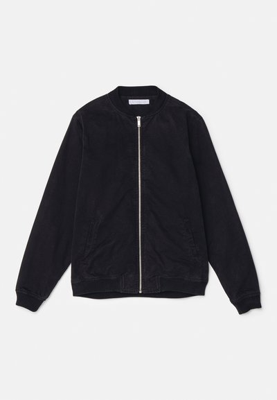 Chaqueta bomber negra hecha de tejido suave, con cierre de cremallera, puños y cuello acanalados, y dos bolsillos frontales.