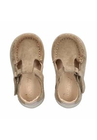 Lichtbeige suède peuterschoenen met een uitgesneden ontwerp, gestikte details en een klittenbandsluiting. Zachte textuur en ronde neusvorm.