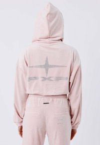 Hoodie in velluto rosa con una grande stella argentata e "PXP" sul retro, caratterizzato da un cappuccio e polsini elastici. Texture morbida, design casual.