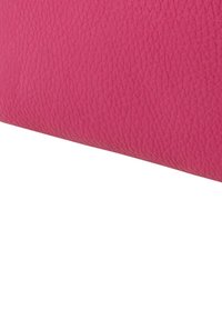 Rosa Leder mit strukturierter Oberfläche und einer gebogenen Kante. Fokus auf satten Farbton und detailliertes Narbenmuster.