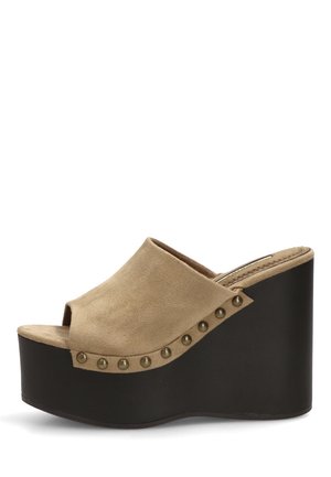 Mula beige de ante con puntera abierta, tachuelas de bronce y un alto tacón cuña de plataforma negra.