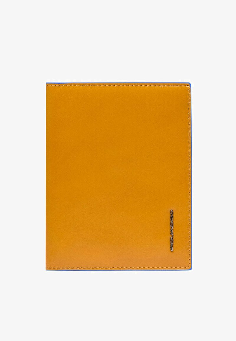 Gele leren notitieboekhoes met blauwe stiksels en een geperst logo in de rechterbenedenhoek. Gladde textuur, rechthoekige vorm.