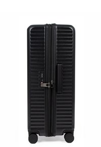 Valigia rigida nera con texture a righe verticali, doppie cerniere, lucchetto a combinazione integrato e quattro ruote girevoli fluide.