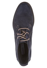 Chaussure décontractée en daim bleu marine à lacets beiges, bout rond et couture visible sur les côtés et à l'avant.