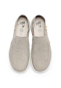 Zapatos beige tipo slip-on hechos de suave gamuza con una parte superior texturizada, punta redondeada y suela de goma blanca contrastante. La marca de la talla 41 es visible en el interior.