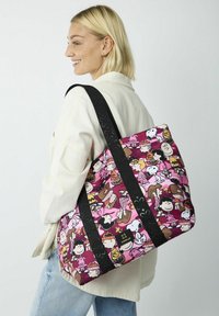 Tas met een roze stof met patronen van cartoonfiguren, zwarte schouderbanden en een logoaccent aan de zijkant.