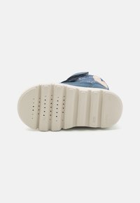 Blå barnsko med en texturerad ovandel, kardborrestängning och vit gummisula som har spår och ventilationshål.