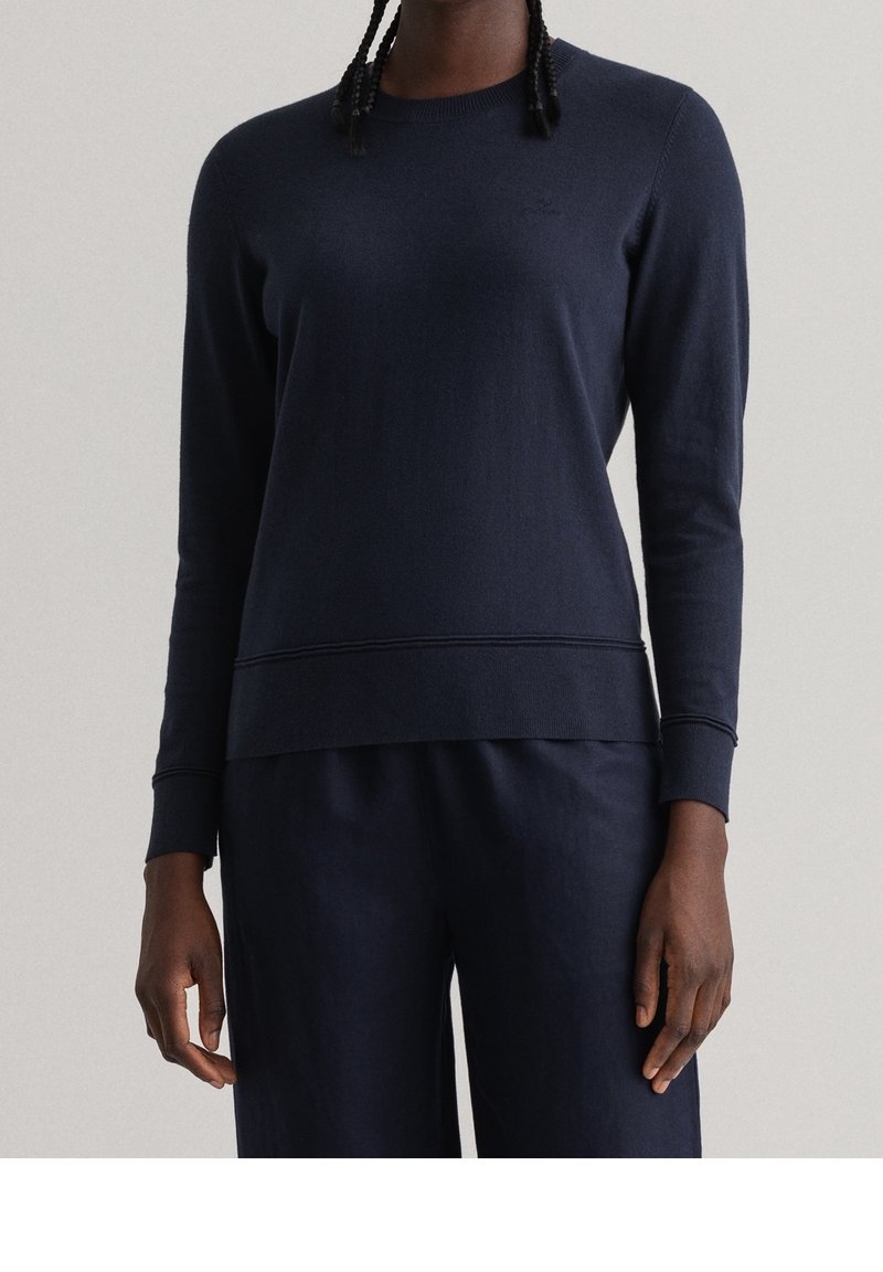 Pull à manches longues bleu marine en maille douce, doté d'un col rond et de poignets et ourlet côtelés pour une coupe décontractée.