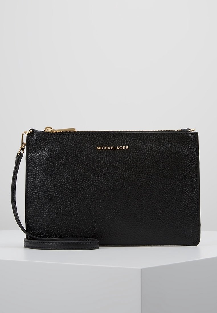 Sort læder clutch taske med en pebret tekstur, guld hardware, lynlåslukning og håndledsrem. Guld "MICHAEL KORS" logo på fronten.