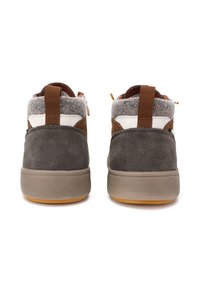 Scarpe alte in suede marrone e grigio con un colletto in feltro grigio testurizzato, dettagli bianchi e una suola in gomma color gomma. Presenti due linguette posteriori.