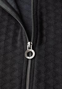 Černá bunda se zipem a diamantovým prošíváním. Stříbrný zip s kulatým táhlem. Hladká, texturovaná látka.