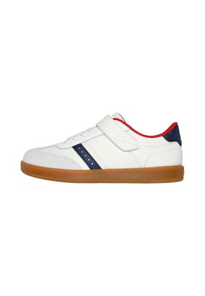 Zapatilla blanca con una franja lateral en azul marino y acentos rojos. Presenta una correa de Velcro, puntera redonda, paneles perforados y una suela de goma.