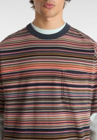 Camisa de manga corta a rayas en marrón, azul marino, gris y rosa. Presenta un escote redondeado y un bolsillo en el pecho izquierdo. Material de algodón suave.