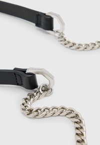 Sort læderrem med sølvmetal kæde, der har et sekskantet lås med branding. Glat tekstur med skinnende metaldetaljer.