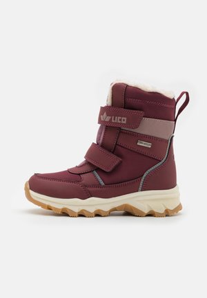 Bota impermeable color marrón con dos correas de Velcro, forro de piel sintética y suela de goma texturizada. Cuenta con una plantilla acolchada y detalle del logo.