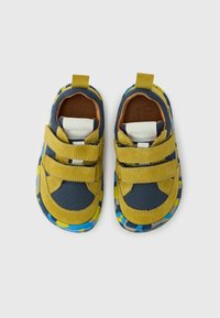 Deux paires de chaussures pour enfants avec un mesh jaune et marine, du daim, des sangles à velcro et une semelle en caoutchouc colorée et à motifs.