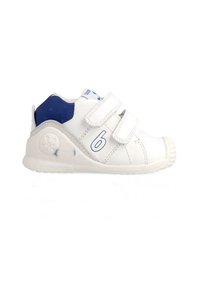 Zapatilla deportiva blanca con acentos azules, fabricada en material sintético. Presenta correas de Velcro, una punta redondeada y una suela de goma texturizada.