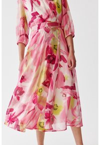 Kwiatowa sukienka midi z przezroczystego, lekkiego materiału, z różowymi, żółtymi i zielonymi kwiatami w stylu akwareli. Zawiązywany krój z ściągniętą talią.