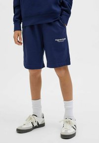 Shorts in cotone bleu navy con una vestibilità rilassata, caratterizzati da un logo ricamato "Original Studio" sulla gamba sinistra e una superficie liscia.