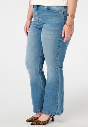Wijd uitlopende blauwe spijkerbroek met een getailleerde taille, vijf-pocket ontwerp en een lichte wasbeurt. De zoom heeft een aangebrande rand en is gecombineerd met leopaardprint hakken.
