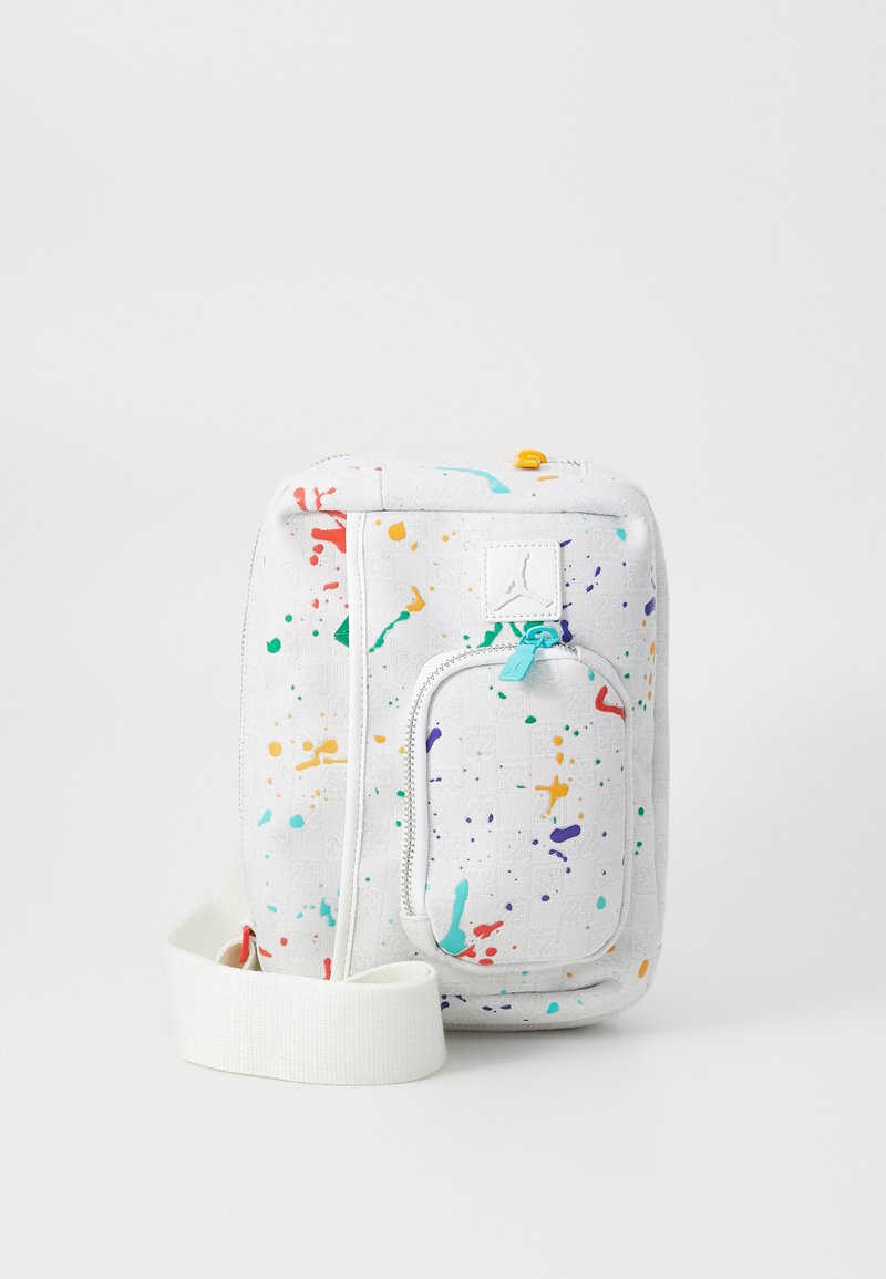 White fabric shoulder bag with colorful splatter patterns, featuring a front zip pocket, adjustable strap, and a logo patch.