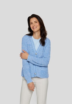 Hellblaues Cardigan mit strukturiertem Strickmuster, V-Ausschnitt und vorderen Knöpfen. Über einem hellblauen Oberteil getragen und mit hellen Hosen kombiniert.
