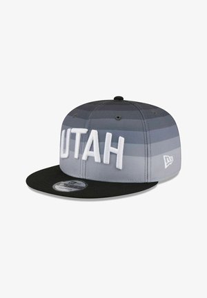 Cappellino grigio e nero a strisce orizzontali, con la scritta "UTAH" ricamata in bianco sul davanti e visiera piatta. Logo New Era sul lato.