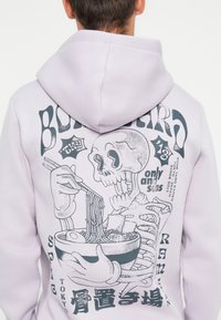Light purple hoodie featuring a graphic print of a skull eating ramen with chopsticks, detailed with black accents and text elements.