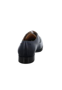 Chaussure habillée en cuir bleu marine avec une finition lisse, un bout arrondi et un petit talon. Présente des coutures simples le long de l'arrière et du côté.