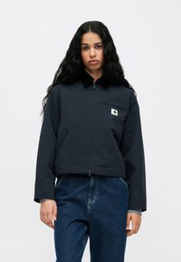 Ναυτικό κοντό μπουφάν με γιακά, κλείσιμο με φερμουάρ και μπροστινή τσέπη στο στήθος. Διαθέτει λογότυπο και ανθεκτικό, υφασμάτινο υλικό.