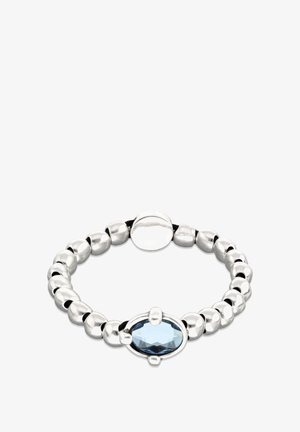 Anillo plateado con cuentas que presenta un engaste de piedra preciosa ovalada de color azul claro. Las cuentas lisas y texturizadas alternan en tamaño y forma.
