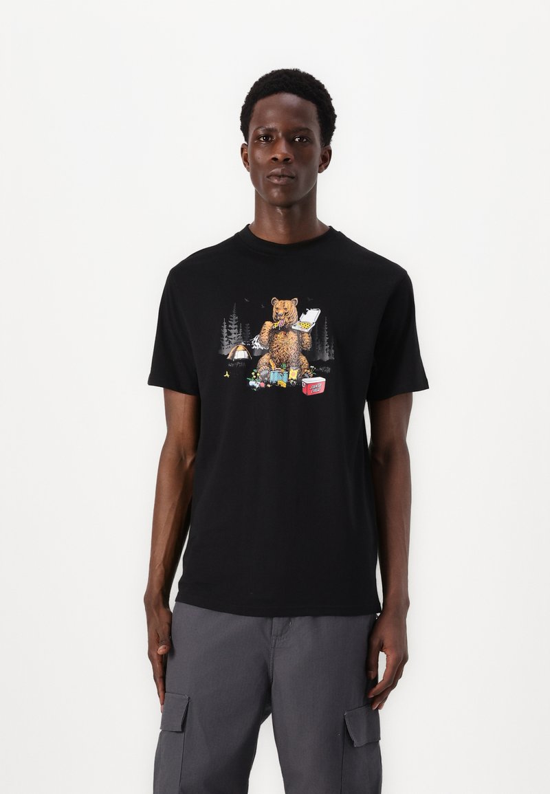 Zwarte katoenen T-shirt met een cartoonbeer in kampeeruitrusting, voor een bosachtergrond, ronde halslijn, korte mouwen.