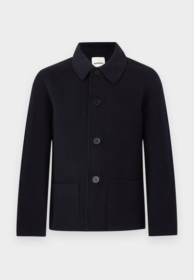 Μαύρο ανδρικό μάλλινο σακάκι με γιακά, τέσσερα μαύρα κουμπιά και δύο εμπρόσθιες τσέπες, εμφανιζόμενο σε απλό λευκό φόντο.