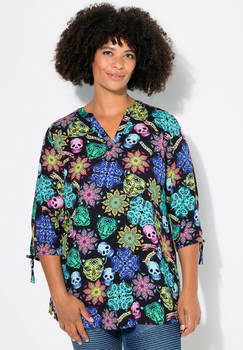 Schwarze Bluse mit bunten Blumen- und Totenkopf-Mustern, Dreiviertelärmel und V-Ausschnitt. Der Stoff wirkt glatt mit einem leicht schimmernden Finish.