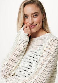 Maglione bianco lavorato a maglia con una trama aperta e un design a strisce testurizzate. Presenta maniche lunghe e un collo rotondo. Accenti di motivo discreti.