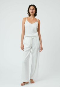Completo bianco leggero composto da due pezzi, con un top senza maniche a scollo a V e pantaloni larghi con elastico in vita e vestibilità comoda.