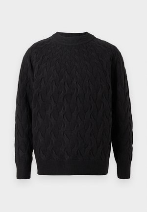 Crni džemper od pletenog tkanja sa okruglim izrezom, koji ima teksturirani uzorak i rebraste manžete i rub za dodatne detalje.