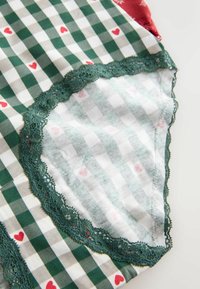 Grün-weiß kariertes Stoffdesign mit roten Herzakzenten, versehen mit einer zarten grünen Spitzenborte entlang der Kanten und einer weichen Textur.