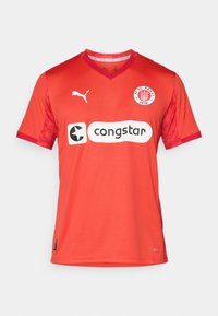 Maillot de foot rouge à manches courtes avec col en V, arborant le logo Puma, le badge du FC St. Pauli et le logo du sponsor congstar à l'avant. Étiquette DryCELL en bas.