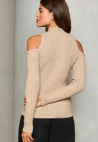 Beige přízí vroubený svetr s odhalenými rameny, dlouhými rukávy, texturovaným detailem na rukávech, přiléhavým střihem a jemnou pleteninou.